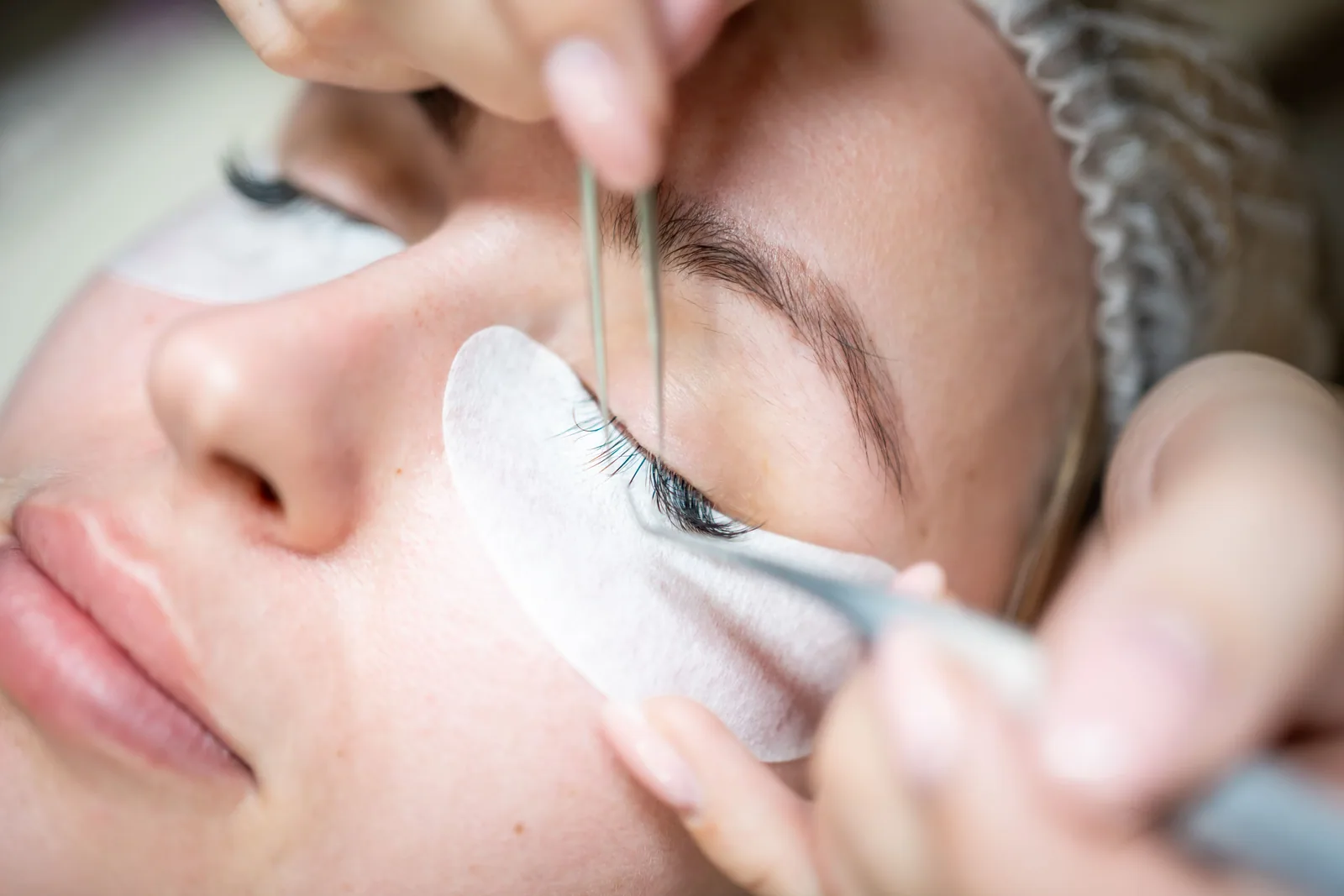 Specialist plaatst wimperextensions bij een klant
